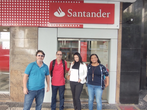 Os dirigentes sindicais Marcos Vicente, Wanderlei Souza e Tânia Belém (D) comemoram o retorno da bancária do Santander, Maria José da Silva Moraes (de posse do documento de reintegração), ao seu emprego