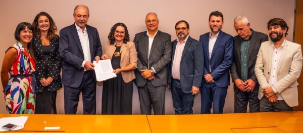 A presidenta da Contraf-CUT com o presidente do BNDES Aloizio Mercadante na assinatura dos dois novos acordos. José Ferreira (sexto da esquerda para a direita) e Vinícius Assumpção (penúltimo), além de representantes da Associação de Funcionários, também participaram da solenidade