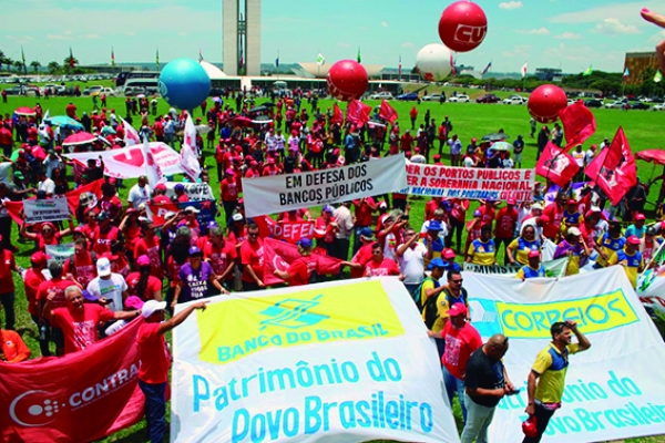Manifestantes protestam em Brasília, tendo ao fundo o Congresso Nacional, contra o projeto do governo de privatizar empresas e bancos públicos e retirar direitos dos trabalhadores