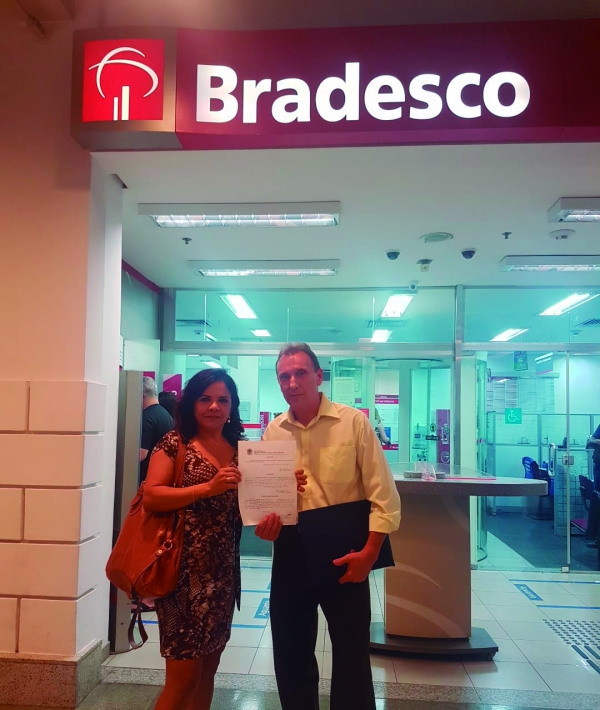 O bancário César Ricardo da Silva de posse de seu documento de reintegração, ao lado da diretora do Sindicato, Sandra Torres