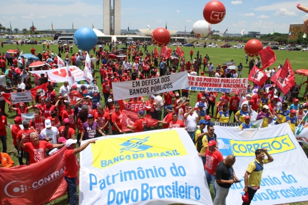 Manifestantes protestam em Brasília, tendo ao fundo o Congresso Nacional, contra o projeto do governo de privatizar empresas e bancos públicos e retirar direitos dos trabalhadores