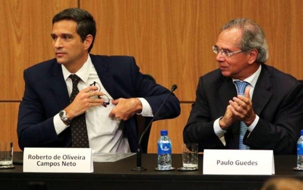 Roberto Campos Neto, presidente do Banco Central (E) e Paulo Guedes, Ministro da Economia: ganhando muito dinheiro com a política de câmbio que eles mesmos determinam para o Brasil